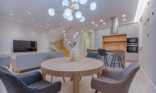 Stylish open-plan living room and kitchen with modern furnishings and lighting.