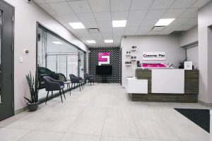 A sleek and modern car detailing shop interior featuring a waiting area and receptionist desk.