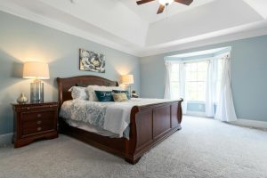 Spacious and elegant bedroom featuring classic wooden furniture and soft lighting.