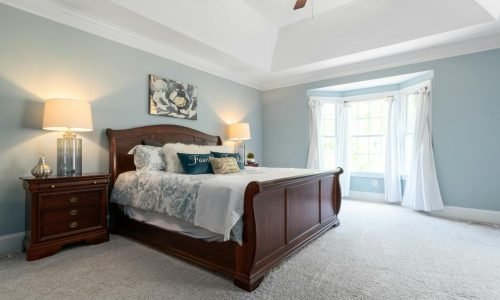 Spacious and elegant bedroom featuring classic wooden furniture and soft lighting.