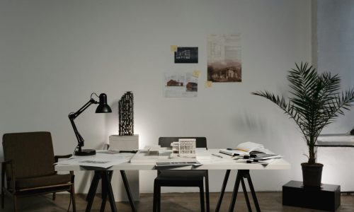 Minimalist architecture office with modern decor, white desk, and stylish layout.